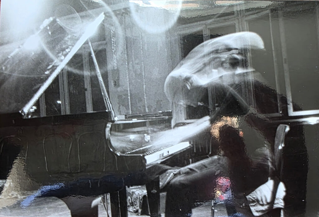 Art-Oliver Simon seated at the piano during a performance at BLAUBETON Kulturetage in Berlin.