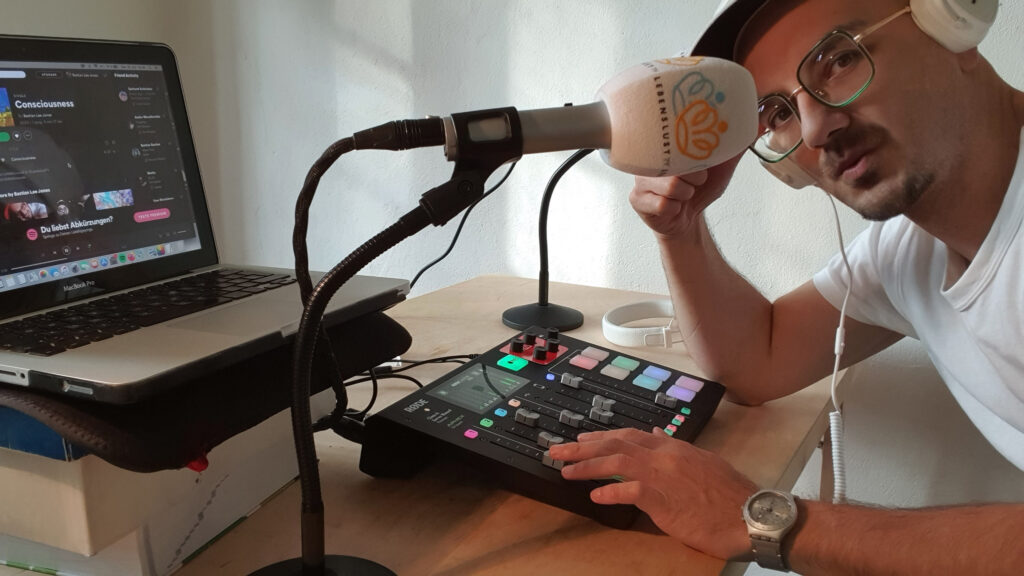 Bastian Lee Jones at a radio and podcast production desk with microphone, mixer and laptop.