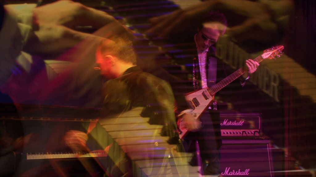 Layered performance photograph showing Kian Lee at the piano and a guitarist Martin Brehl playing on stage under coloured lighting.