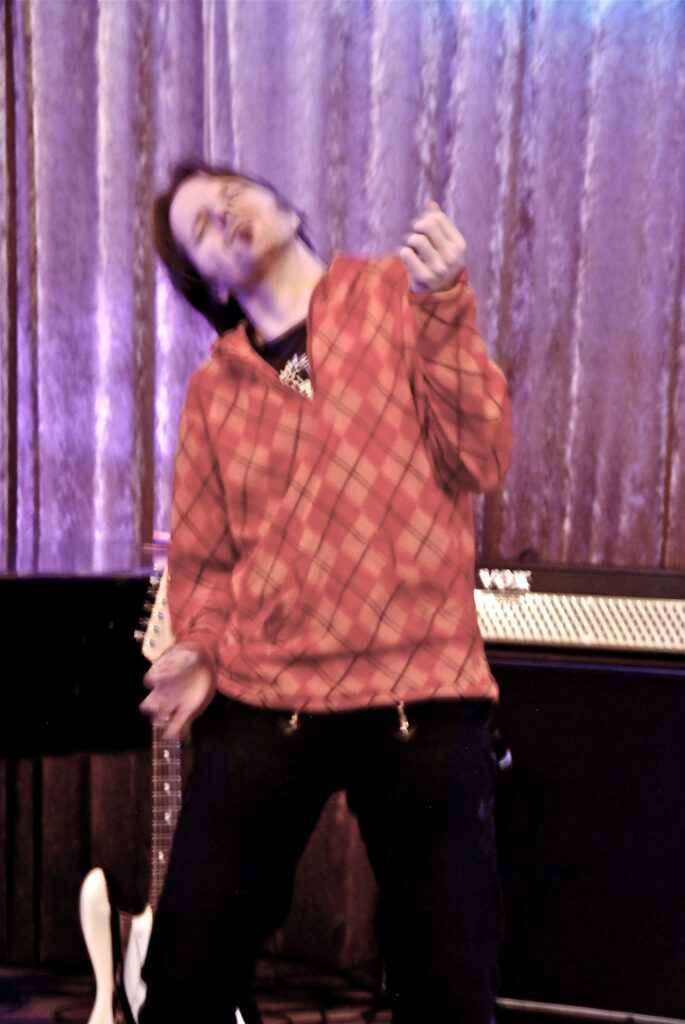 Bassist Nils Wolf Bartels playfully miming air guitar or air bass during the general rehearsal.